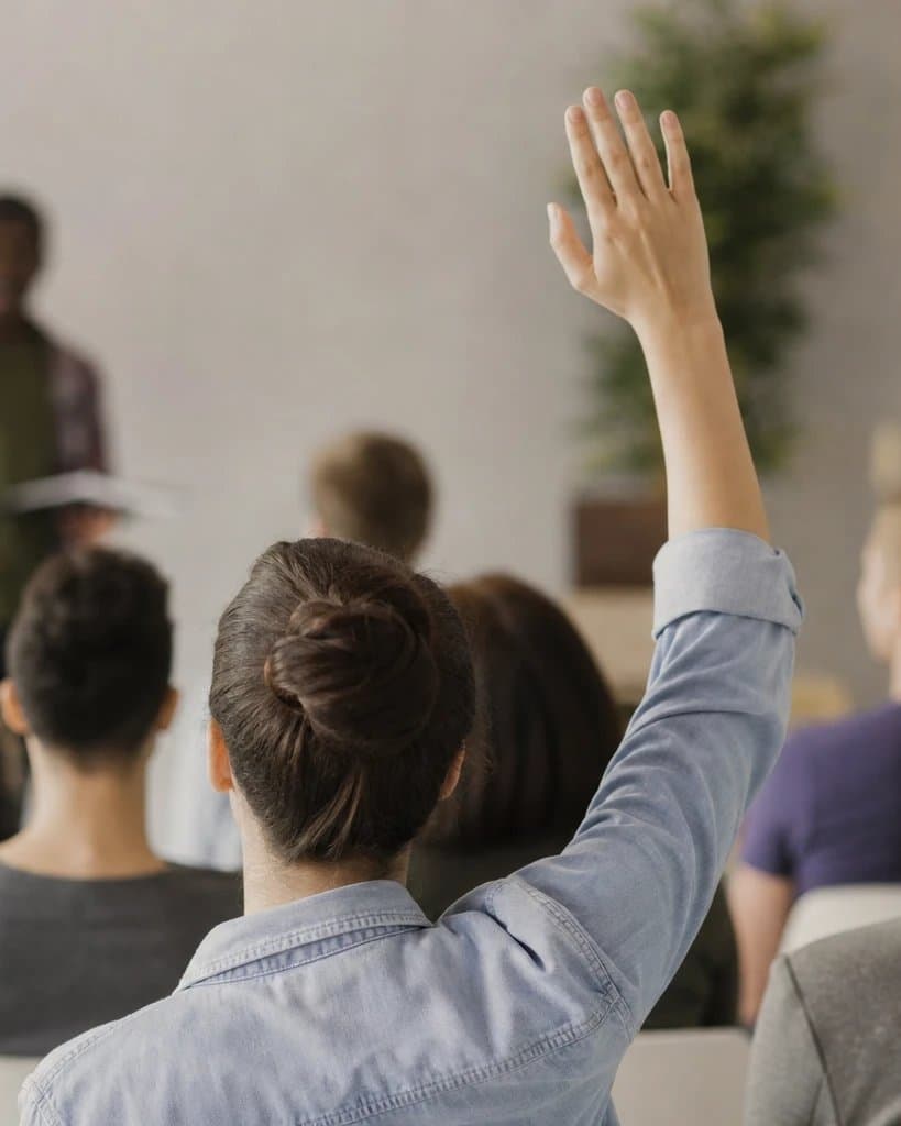 A participant raising their hand during a group learning session